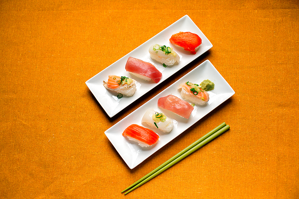 Sushi platter, a selection of raw fish and rice snacks with chopsticks.