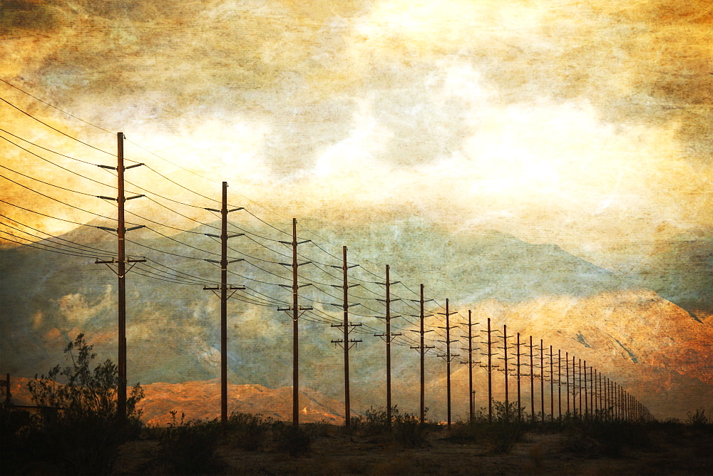 Power lines in rows across the landscape, against a sunset sky, California, USA