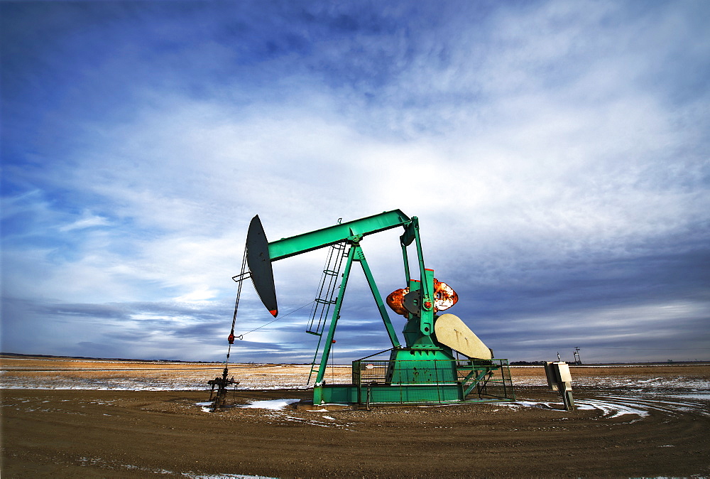 An oil pump jack at a drilling site for oil, an oil field in SaskatchewanOil field pump jack, Saskatchewan, Canada