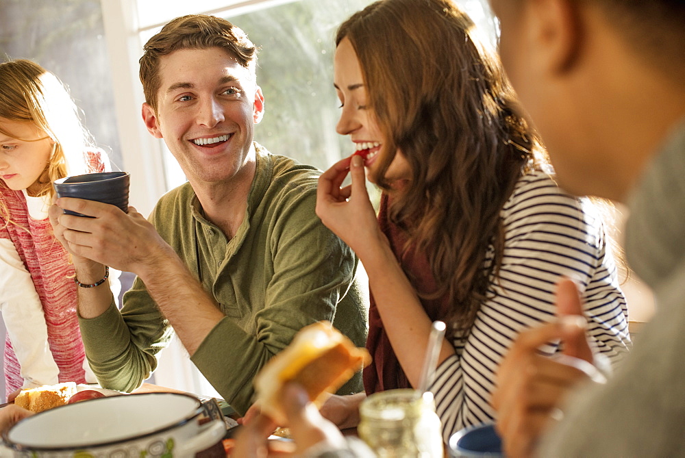 A group of people sitting at a table, smiling, eating, drinking and chatting, Woodstock, New York State, USA