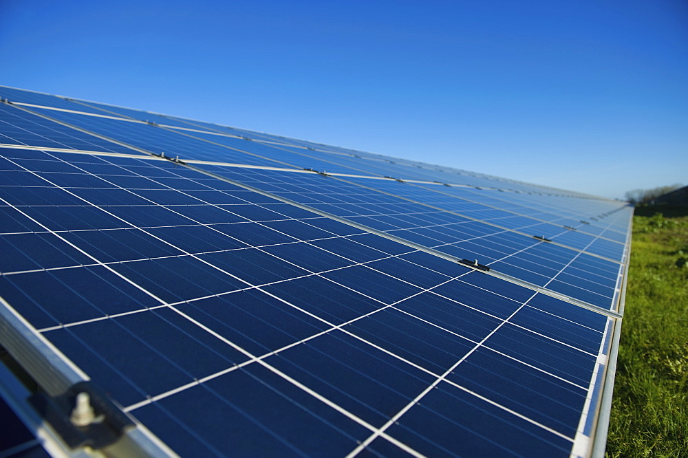 Close up of a row of solar panels in an open field. A solar farm, Gloucestershire, England, United Kingdom