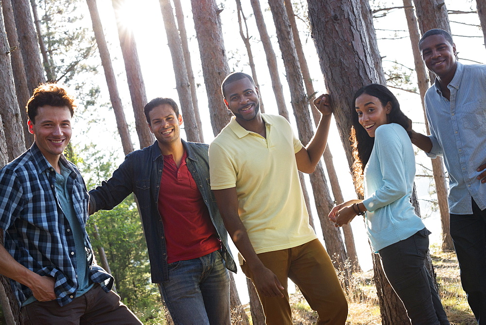 Lakeside. A group of people, friends gathered in the shade of pine trees in summer, Woodstock, New York, USA