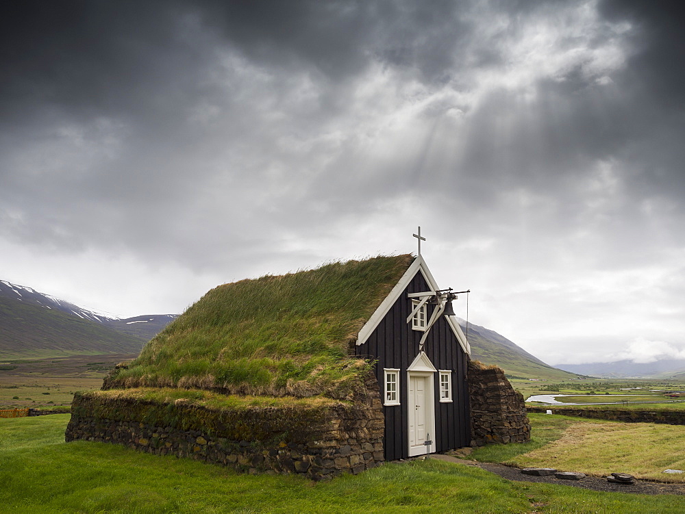 A traditional wooden church with turf roof, earth and grass material on the steep pitched roof, Iceland