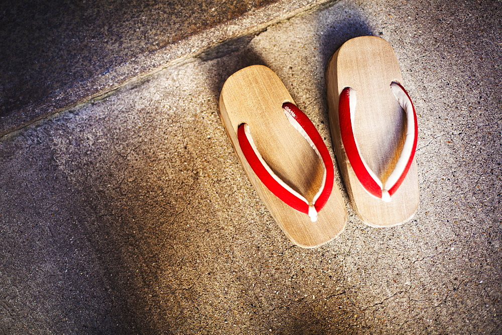 A pair of traditional wooden sandals with thick soles and red straps worn by geisha, okobo or geta, Japan