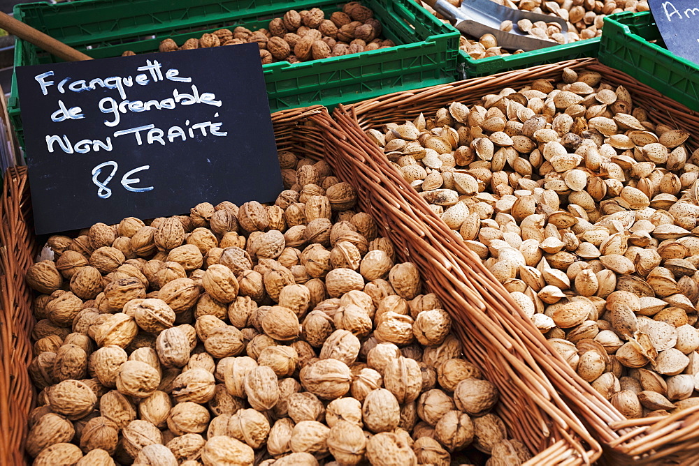 A market stall, fresh produce for sale. Baskets of walnuts and a price sign, France