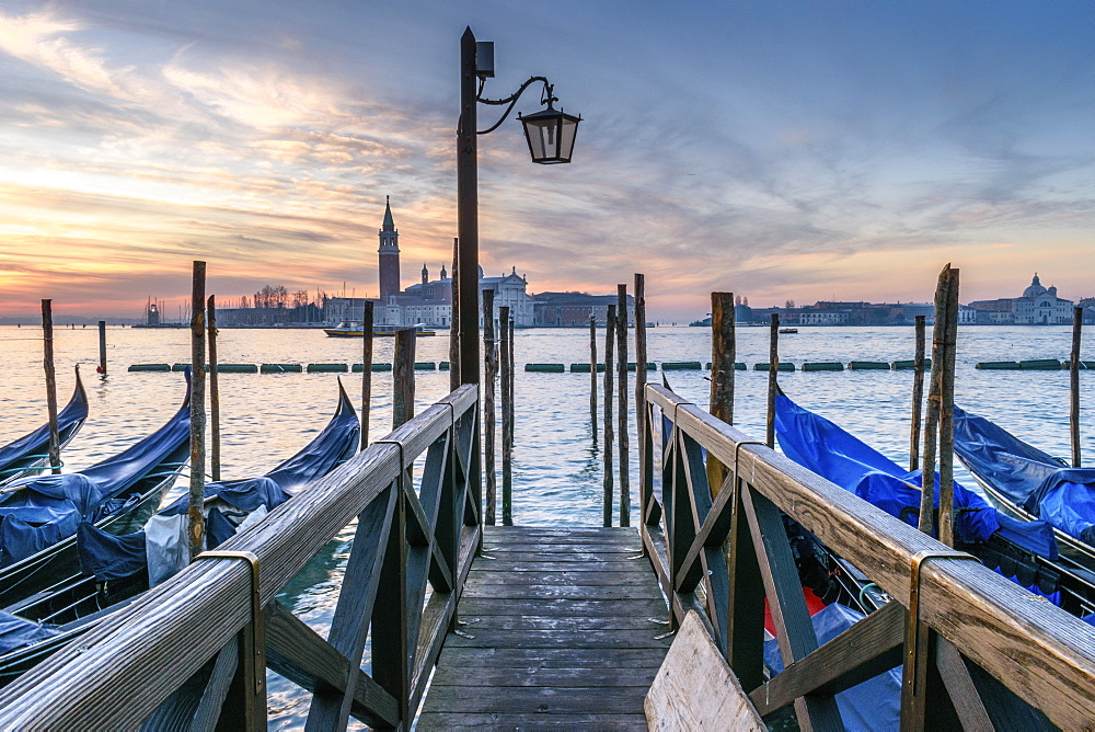 Gondolas moored on a canal in Venice, Italy, at sunrise, Venice, Italy