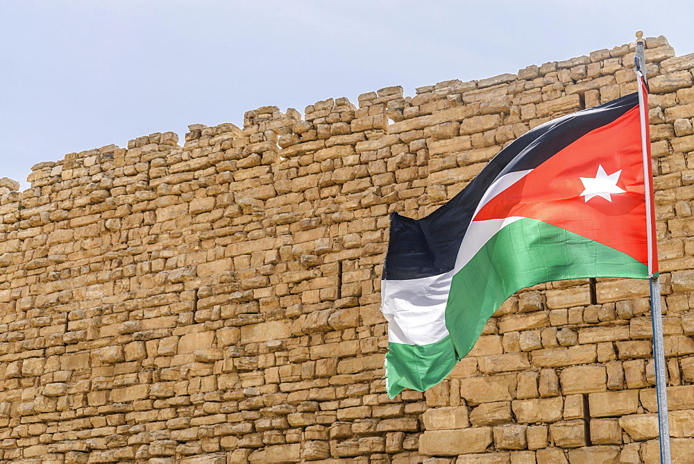 Jordanian flag flying outside stone wall of Kerak Castle, a Crusader castle in al-Karak, Kerak Castle, Jordan