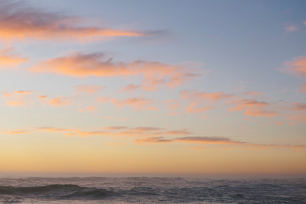 Seascape with cloudy sky at sunset.