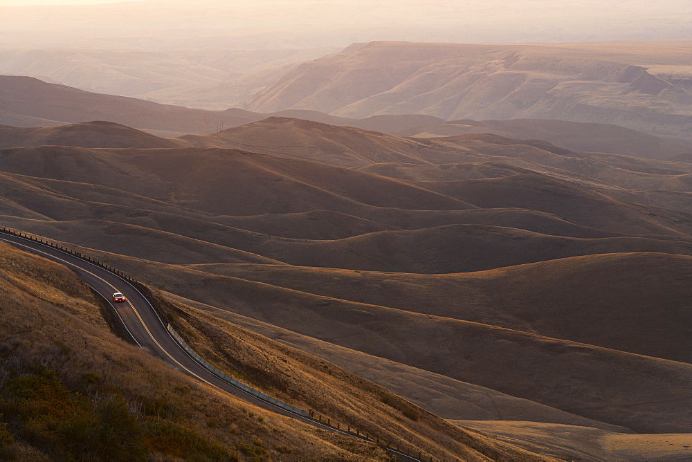 A view looking down of a car moving on a highway at sunrise near Lewiston, Idaho USA, United States of America