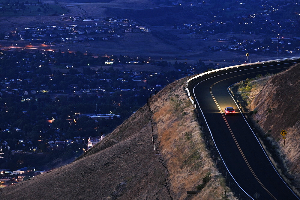 A view looking down on a car moving on a highway almost at dark near Clarkston, Washington, United States of America