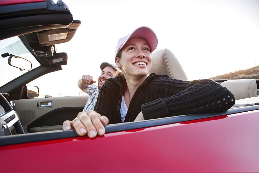 Caucasian couple parked in their sports car convertible, United States of America