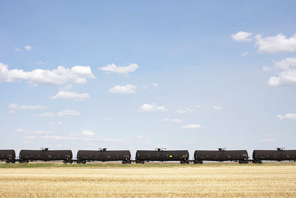 Oil train cars and fallow farmland, near Swift Current, Saskatchewan, Canada