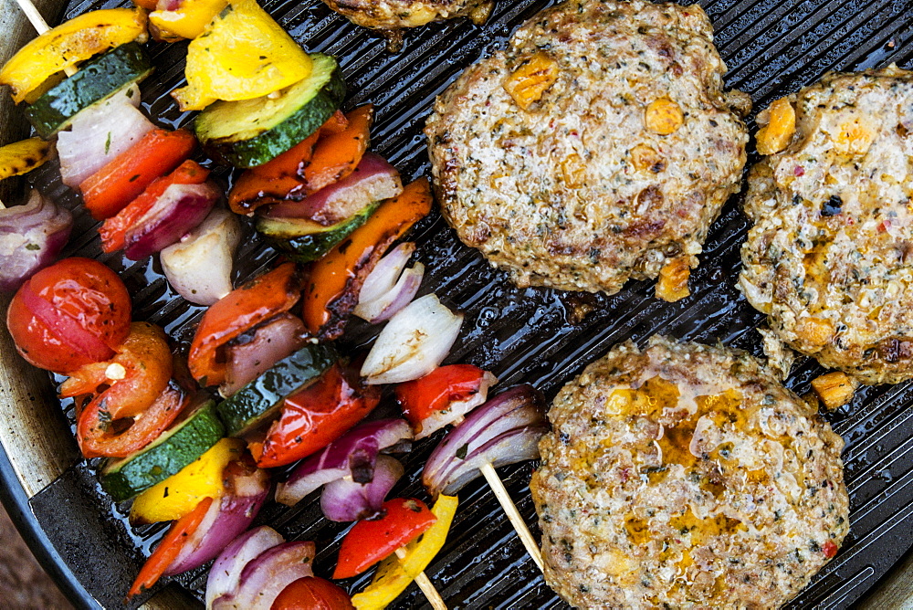 Food on a barbeque, vegetable kebabs and home made burgers, cooking outdoors, Wales