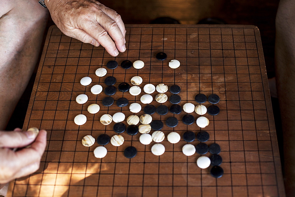 High angle close up wooden Go board with black and white gaming pieces, Kyushu, Japan