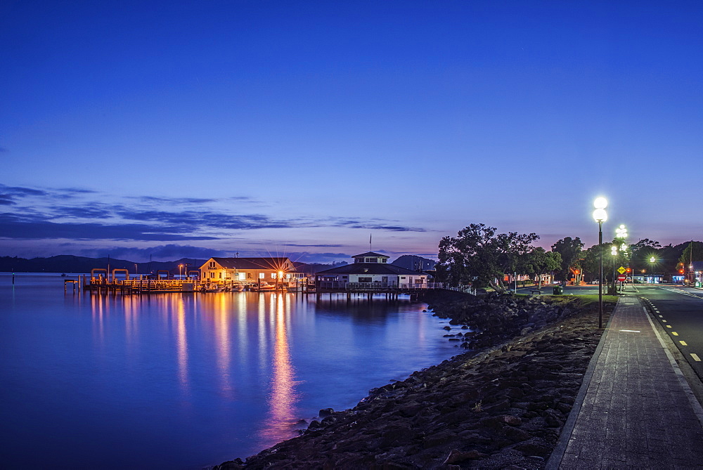 Illuminated buildings on water at dawn, Paihia, Paihia, New Zealand