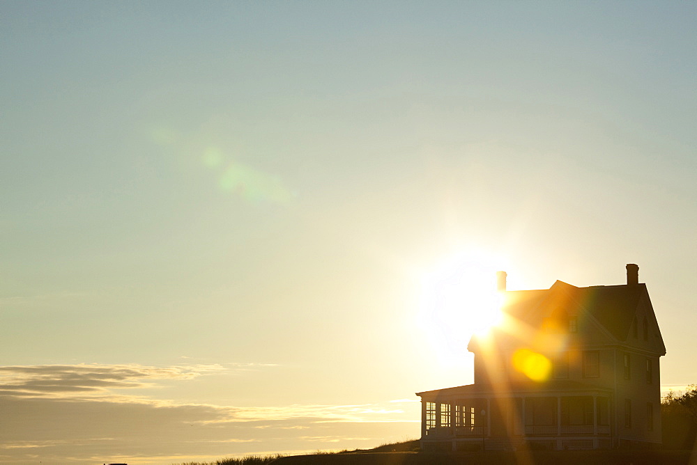 Sun shining behind rural house, Coupeville, Washington, USA