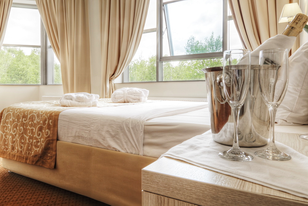 Champagne and glasses by bed in hotel room, Moscow, Russia