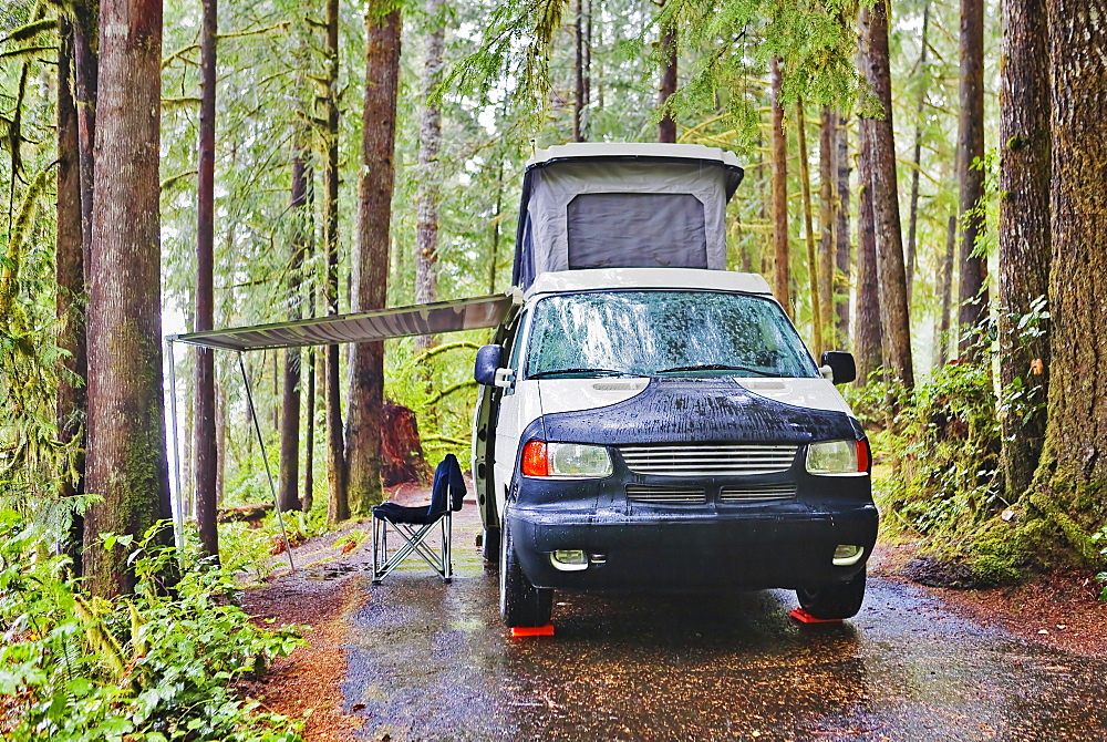 Camper van with awning parked at campsite