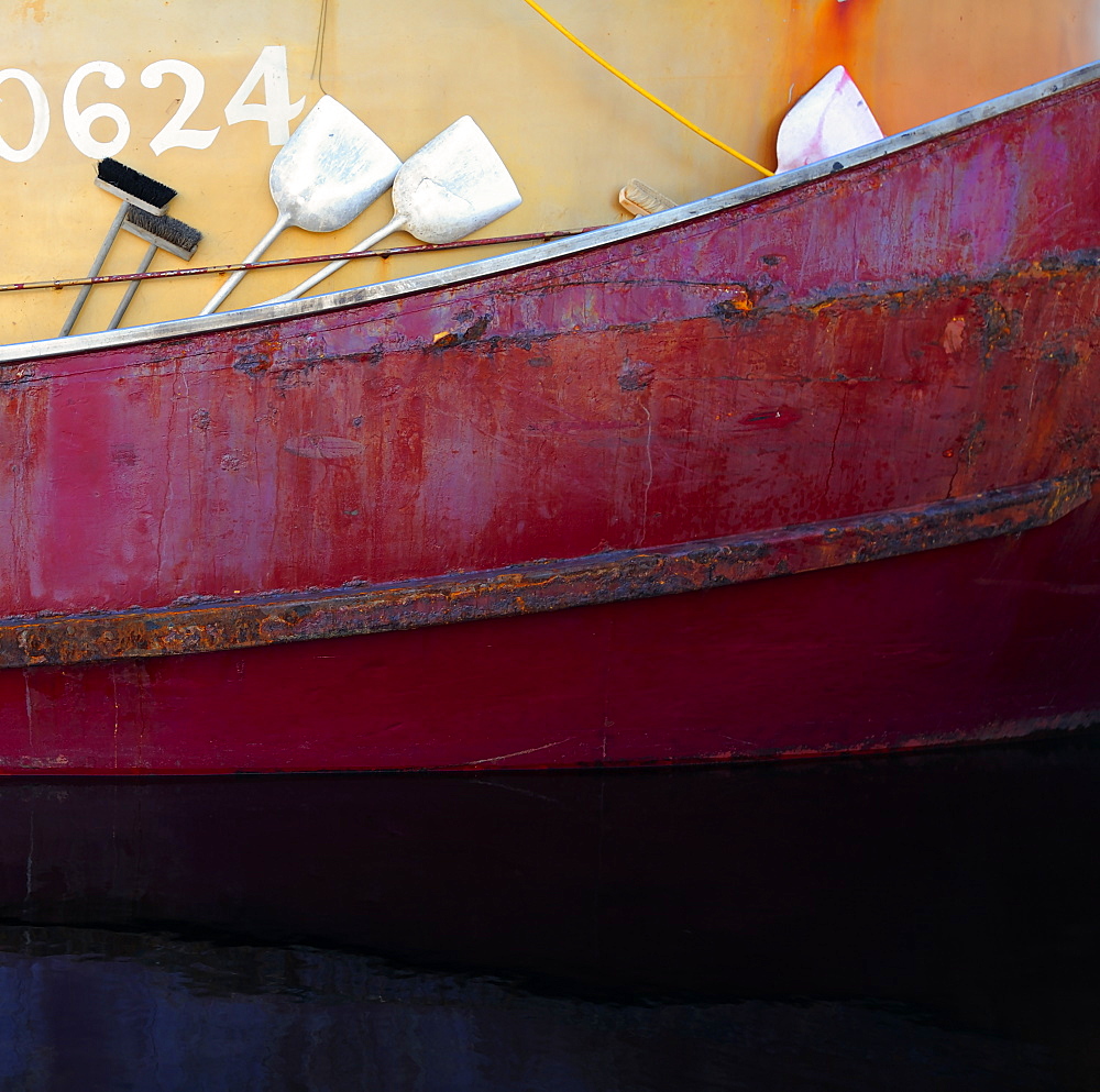 Lifeboat floating by ship in harbor