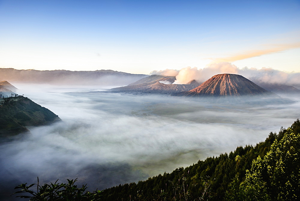 High angle view of clouds under smoking volcano