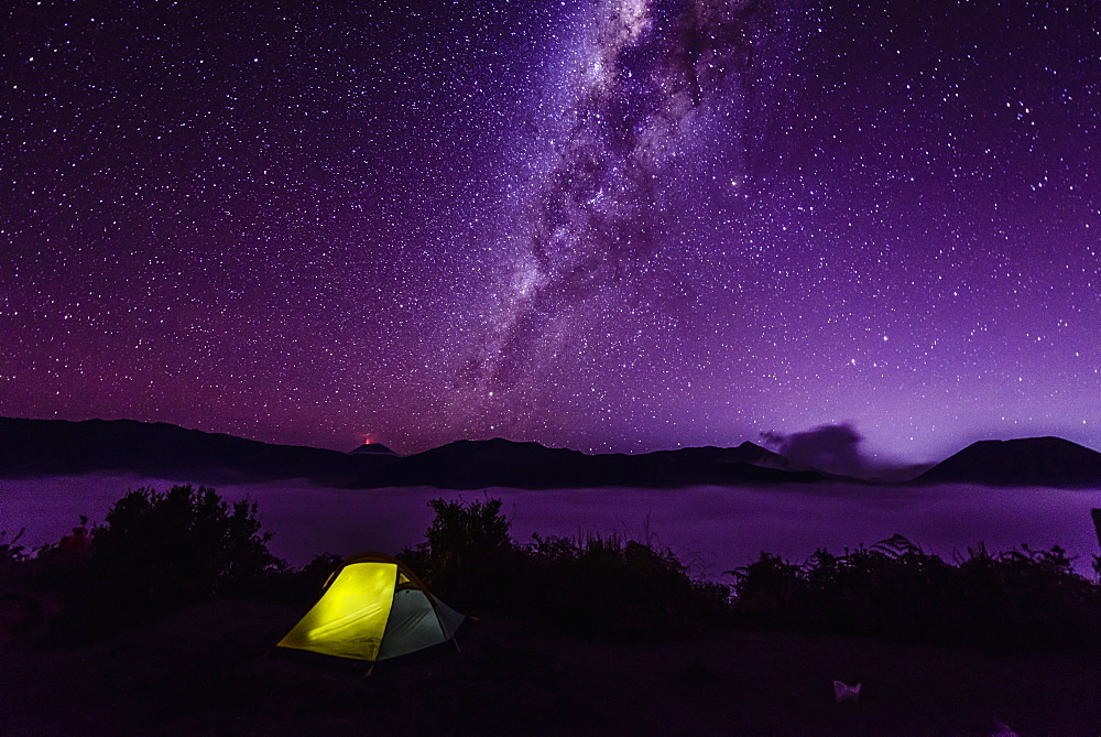 Milky Way galaxy over campsite in starry night sky