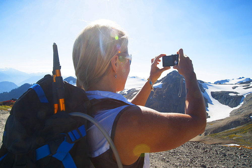 Woman taking photograph of remote mountains