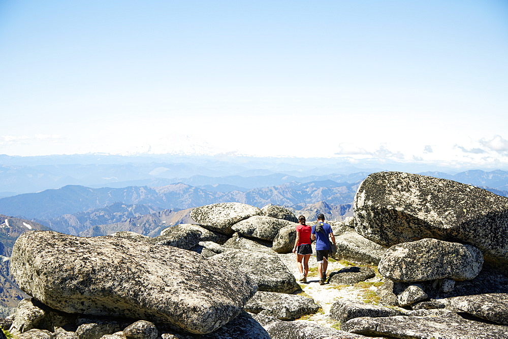 Couple hiking on rocky hilltop, Leavenworth, Washington, USA