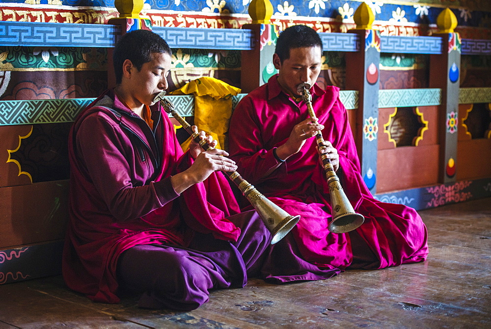 Asian monks playing instruments on temple floor, Bhutan, Kingdom of Bhutan