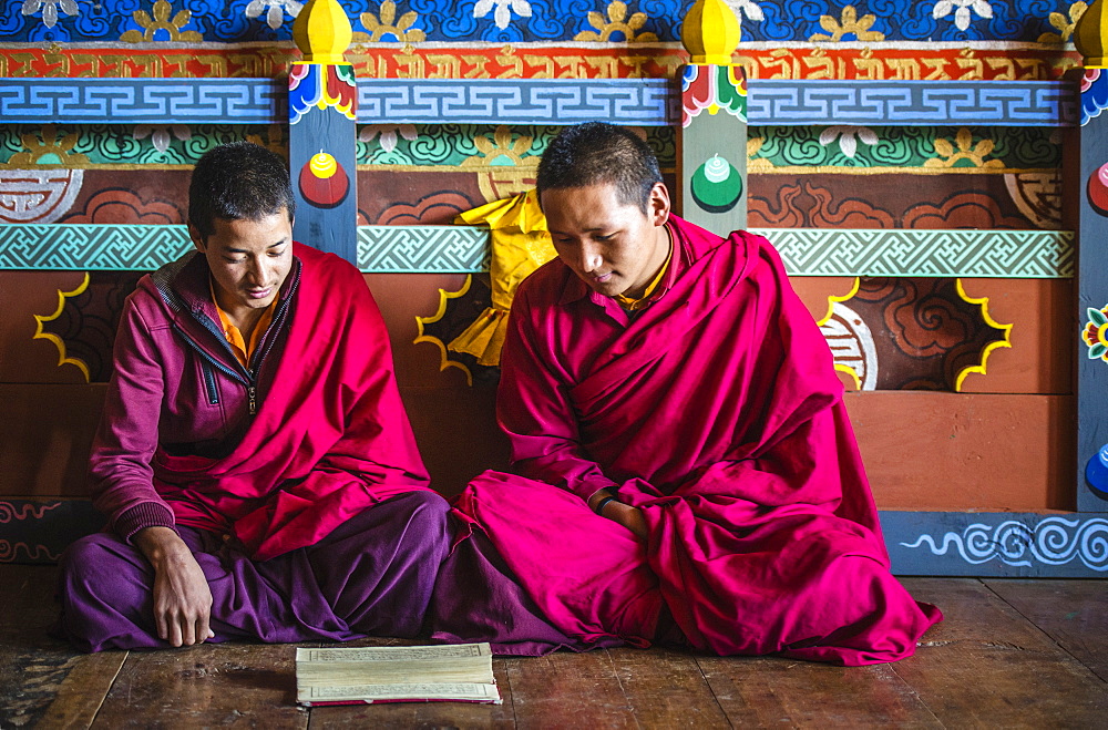 Asian monks reading on temple floor, Bhutan, Kingdom of Bhutan