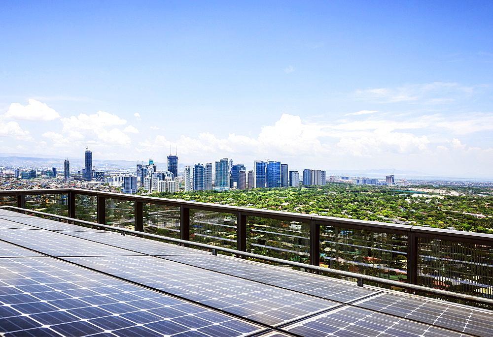 Solar panels and Manila cityscape under blue sky, Philippines, Manila, Philippines