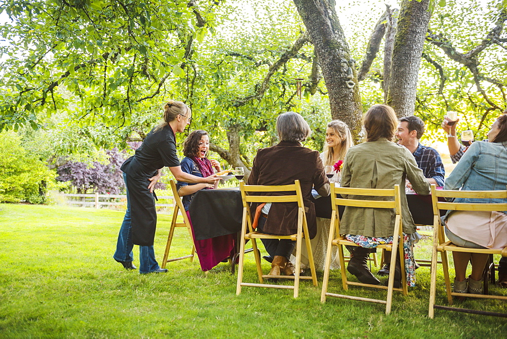 Friends enjoying wine at party outdoors, Langly, Washington, USA