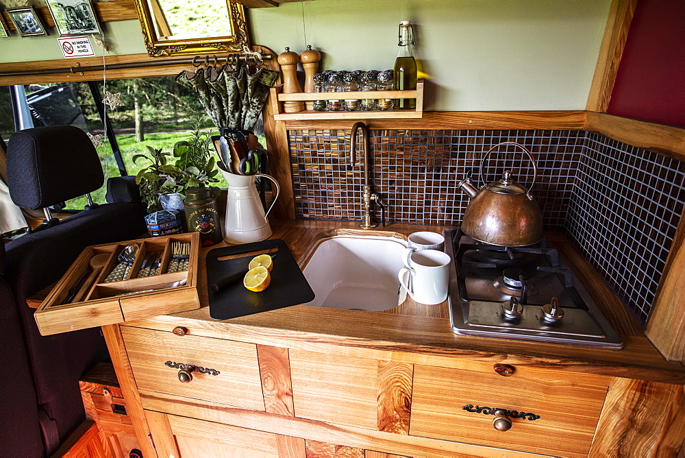 Interior view of camper van with small cooking area and sink, Oxfordshire, England