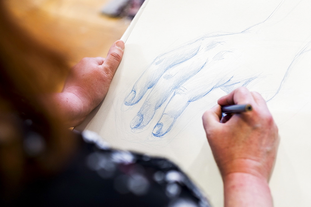 High angle close up of artist drawing human hand, Oxfordshire, England