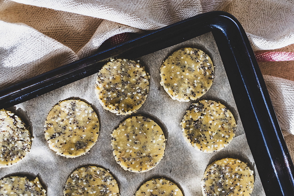 High angle close up of seeded cracker dough on a baking tray, England