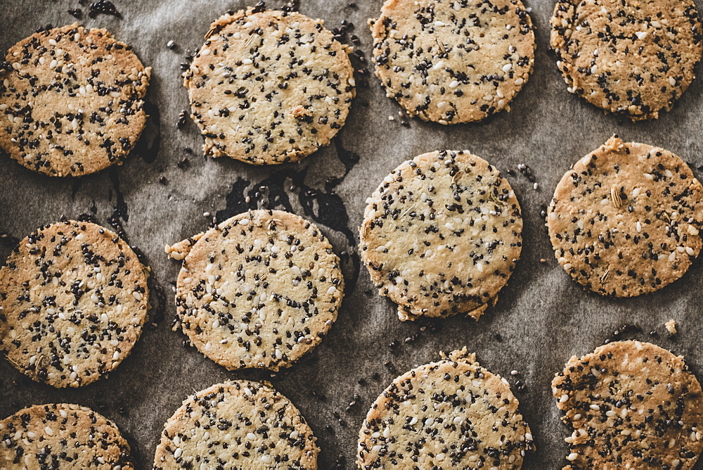 High angle close up of freshly baked seeded crackers on a baking tray, England