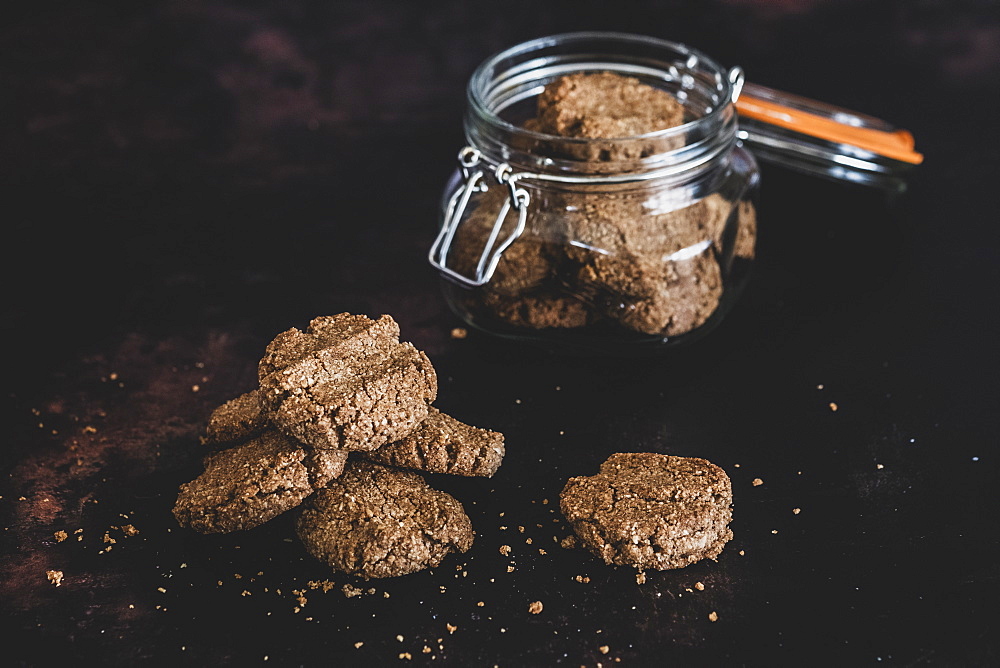 High angle close up of freshly baked chocolate cookies in a glass jar, England