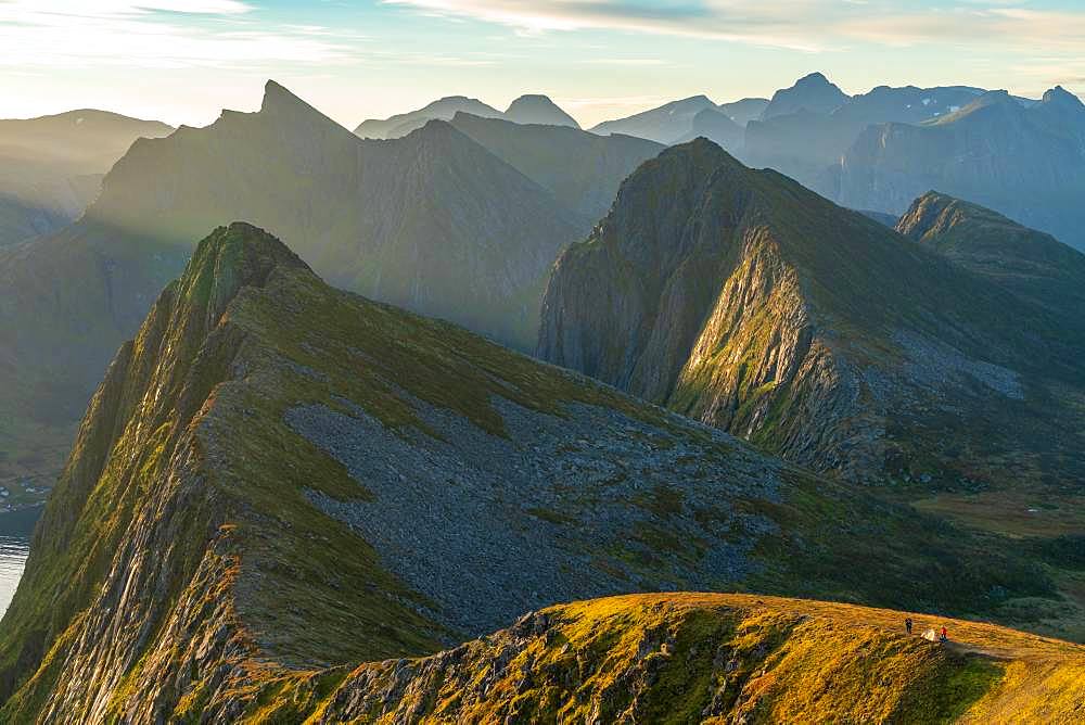 View from above, two people and a tent perched on a ridge in the dramatic peaks of Senja Island, Troms, Senja Island, Lofoten Islands, Norway