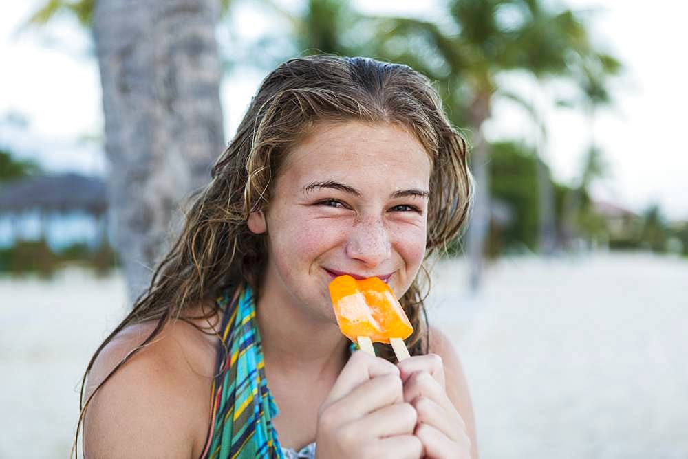 A teenage girl eating a popsicle on holiday, Grand Cayman, Cayman Islands