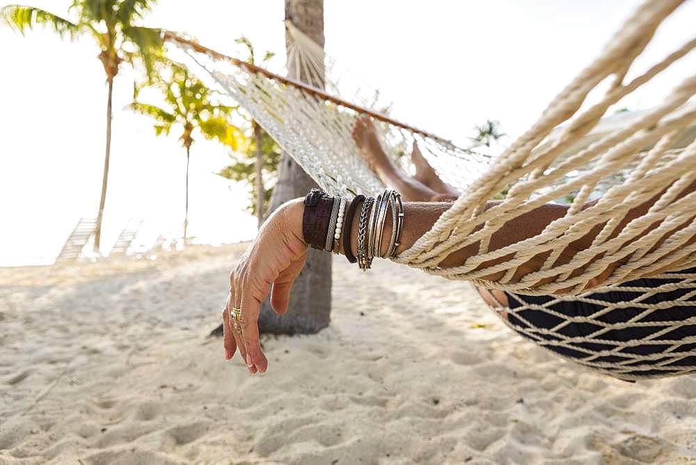 Close up of woman's arm and bracelets, relaxing resting in hammock , Grand Cayman, Cayman Islands