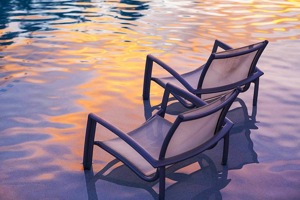 Beach chair in pool at sunset, Grand Cayman, Cayman Islands