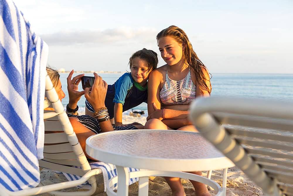 Mother and her children enjoying the beach at sunset, Grand Cayman, Cayman Islands