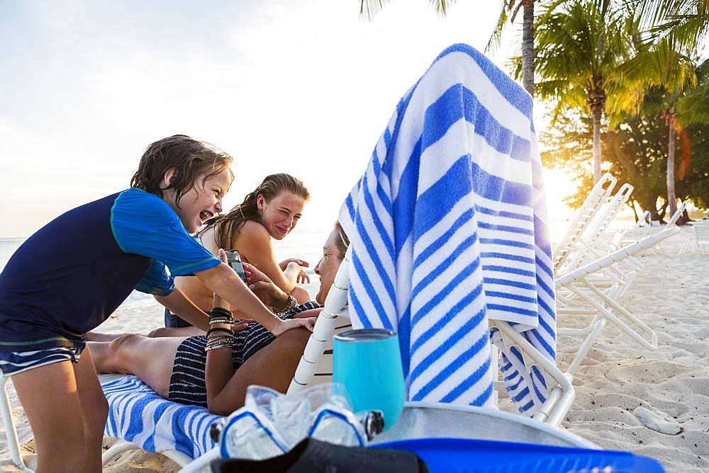 Mother and her children enjoying the beach at sunset, Grand Cayman, Cayman Islands