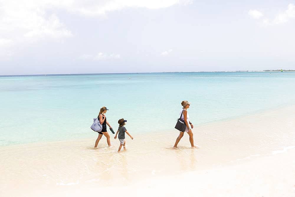 Mother and her children walking the beach, Grand Cayman, Cayman Islands