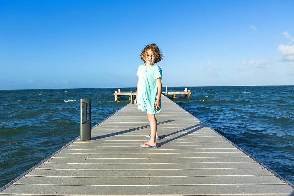 5 year old boy walking on a pier, view to the horizon, Grand Cayman, Cayman Islands