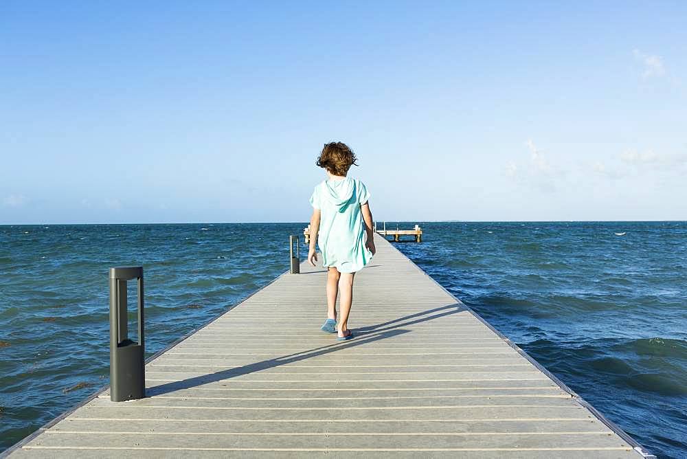 5 year old boy walking on a pier, view to the horizon, Grand Cayman, Cayman Islands