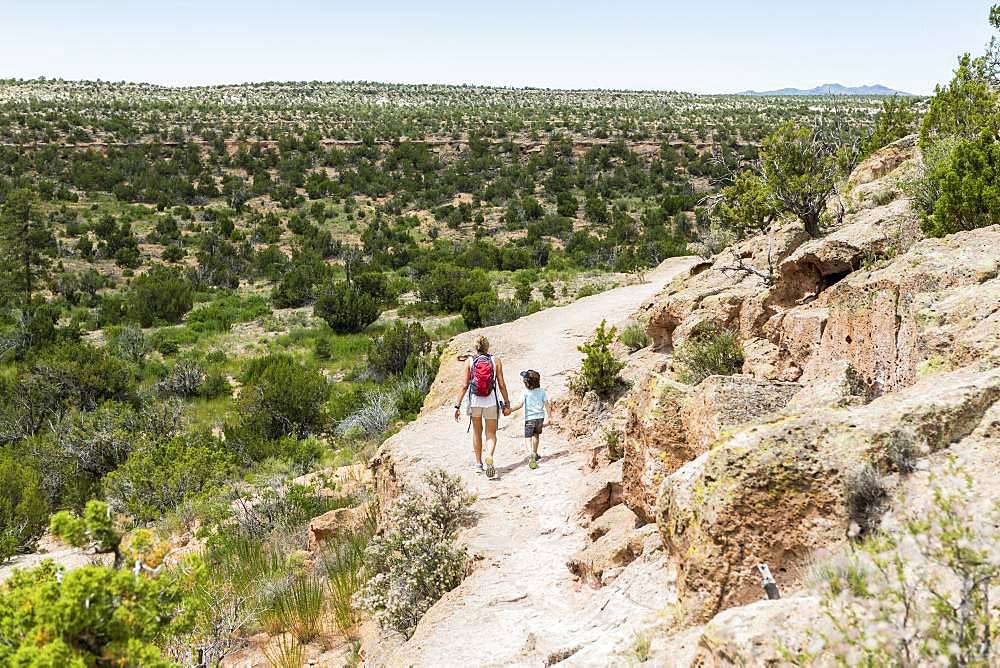 mother and her 5 year old son walking on a path in the New Mexico desert