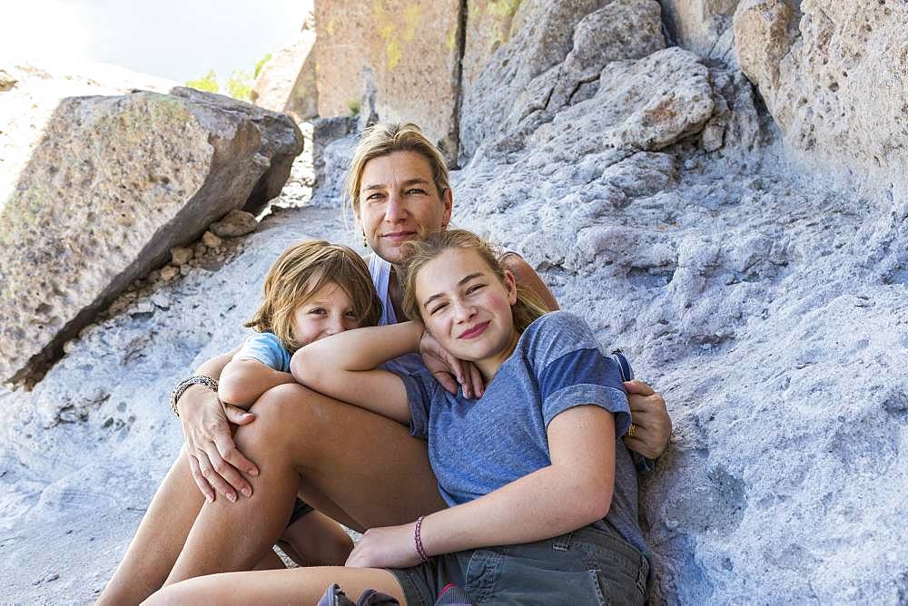 mother and her children sitting on rocks at a desert historic site in New Mexico