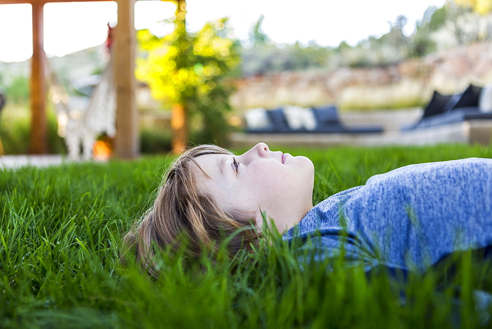 portrait of smiling Six year old boy lying down in green grass