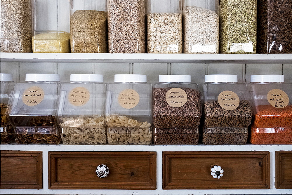 Close up of shelves with a selection of pasta, legumes and grains in glass jars