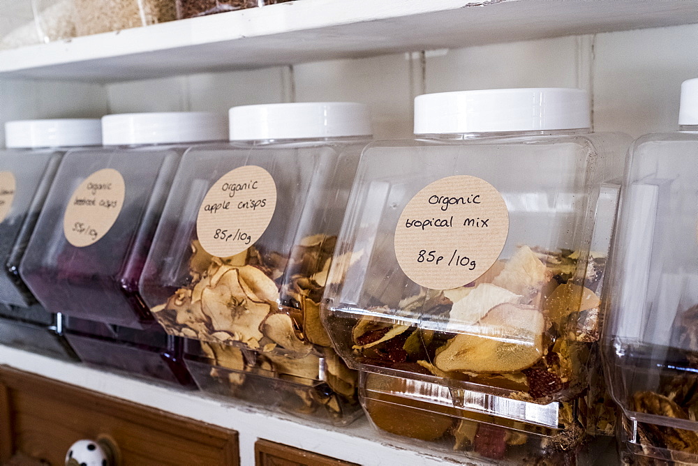 Close up of shelf with a selection of dried fruits in glass jars